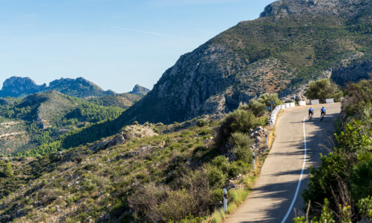 Two cyclists climb a hill in Denia on Thomson Bike Tours training camp